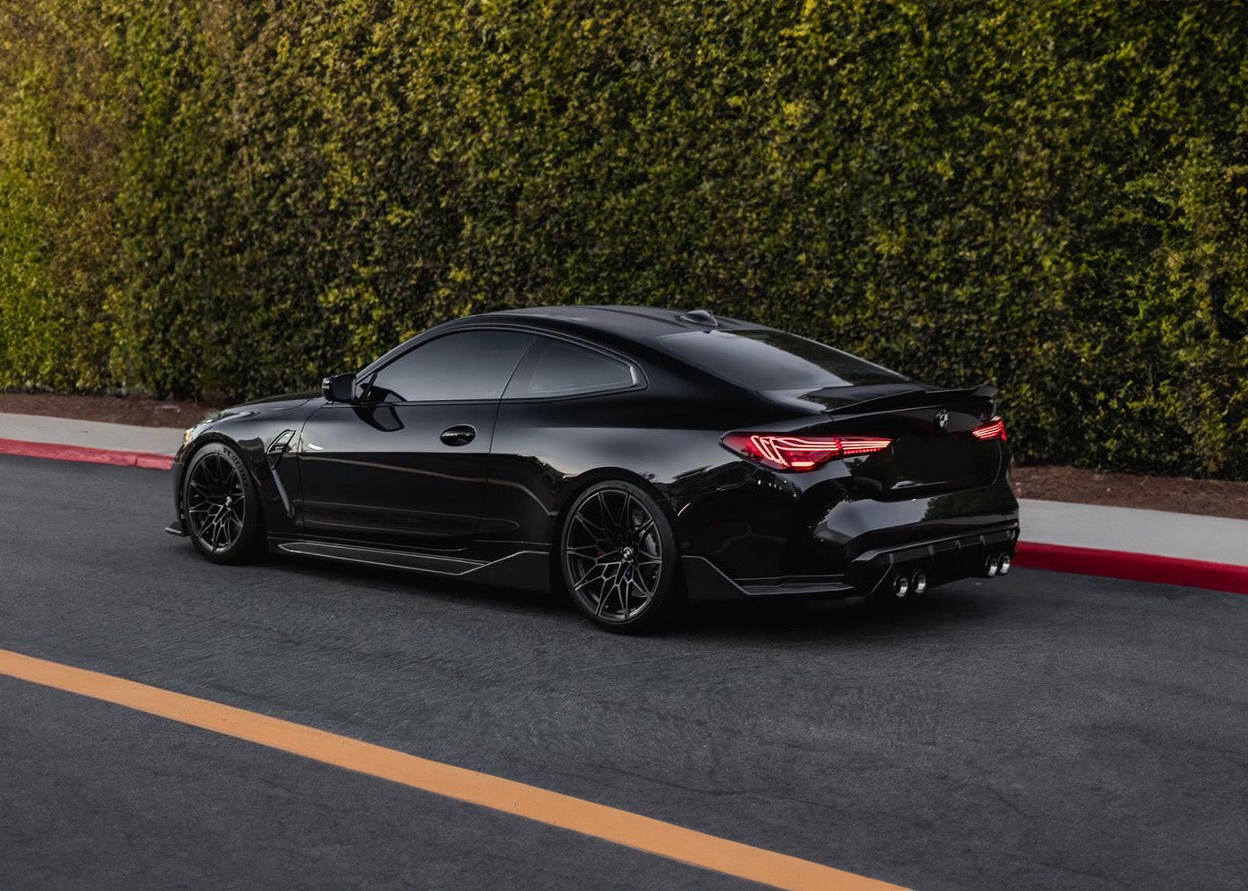 BMW G82 M4 with carbon fibre tail lights, side skirts, rear winglets and rear diffuser on a blacked-out performance build