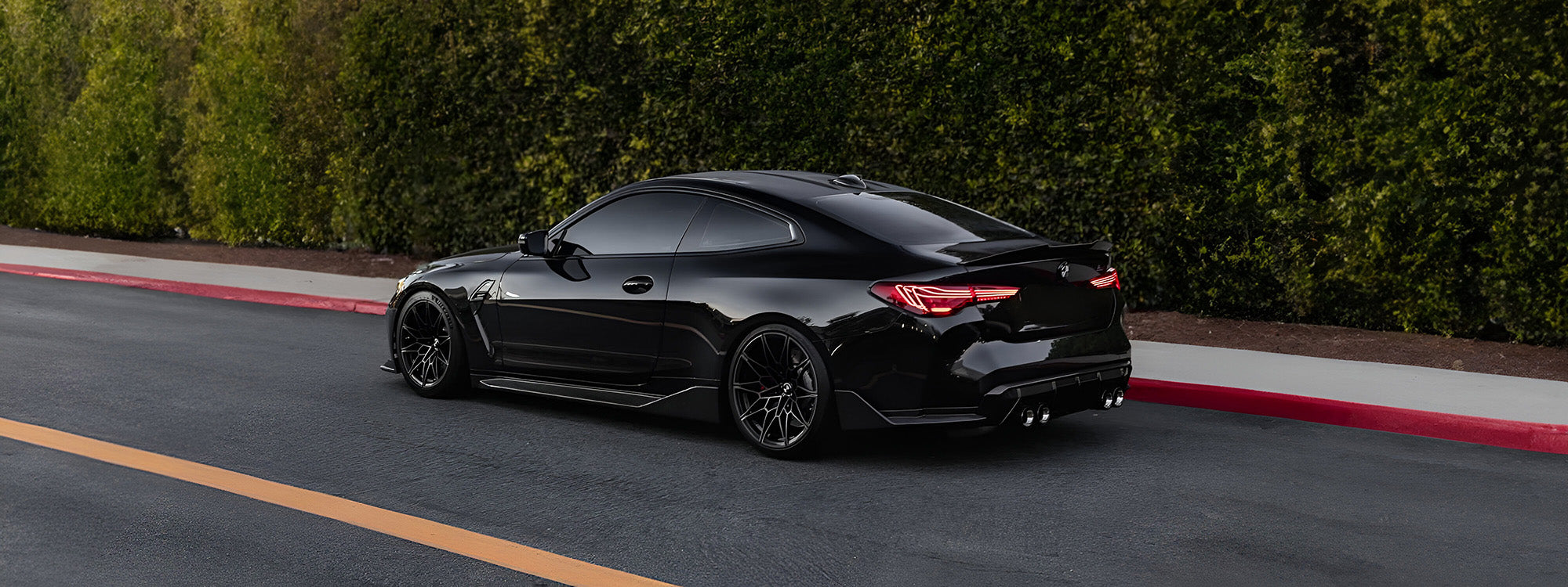 BMW G82 M4 with carbon fibre tail lights, side skirts, rear winglets and rear diffuser on a blacked-out performance build