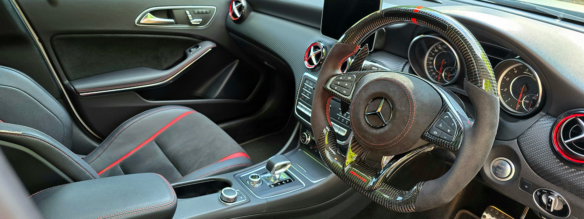 Custom carbon fibre Mercedes AMG-style steering wheel with LED shift lights and magnetic paddles installed in A45 interior