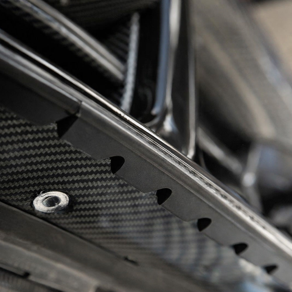 Carbon Noire universal splitter lip protector installed on front splitter edge, close-up view